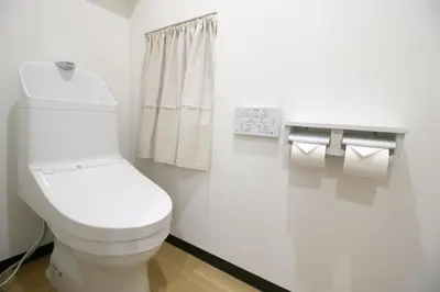 a bathroom with a toilet and two rolls of toilet paper at Uhome\u5343\u99c4\u6728\u9759\u96c5\u6c11\u5bbf\u65c5\u9986 in Tokyo