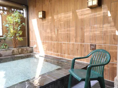 a green chair sitting next to a swimming pool at Dormy Inn Ikebukuro - Natural Hot Spring in Tokyo
