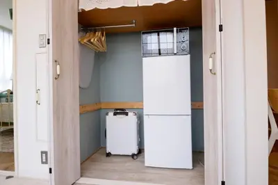 a room with an open door with a refrigerator at Meee Shinjuku in Tokyo