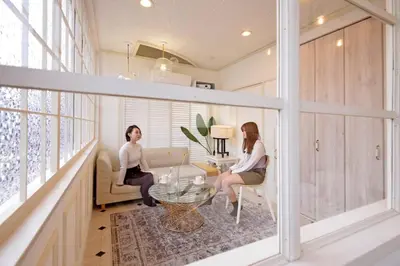 two women sitting in chairs in a living room at Meee Shinjuku in Tokyo