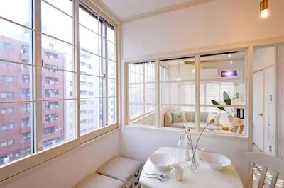 a room with windows and a table and chairs at Meee Shinjuku in Tokyo
