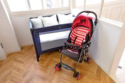a baby stroller next to a bed in a room at Meee Shinjuku in Tokyo