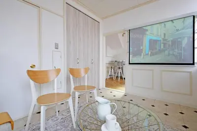 a living room with two chairs and a flat screen tv at Meee Shinjuku in Tokyo