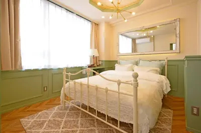 a bedroom with a bed with a mirror and a window at Meee Shinjuku in Tokyo