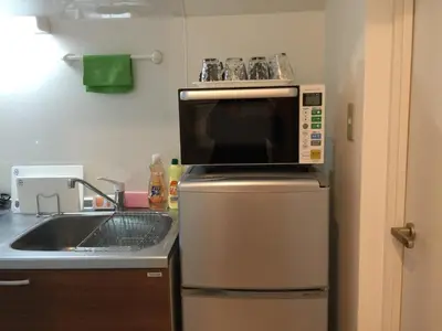 a kitchen with a microwave on top of a refrigerator at Isshuku Ryokan Asakusabashi - Vacation STAY 17363v in Tokyo
