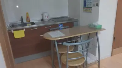 a small kitchen with a table and two stools at Isshuku Ryokan Asakusabashi - Vacation STAY 17365v in Tokyo