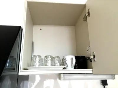 a cabinet with cups and a plate in it at Isshuku Ryokan Asakusabashi - Vacation STAY 17346v in Tokyo