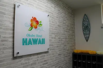a sign on a brick wall with a sign that reads online had hawaiian at Okubo Hotel Hawaii in Tokyo