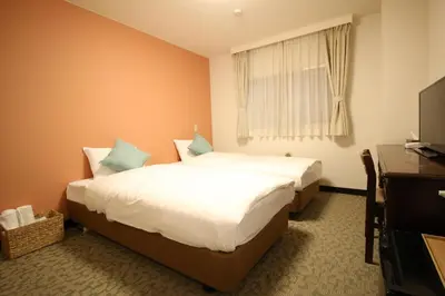 a hotel room with two beds and a television at Okubo Hotel Hawaii in Tokyo