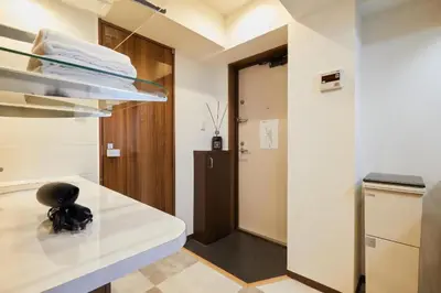 a kitchen with a white counter and a hallway at HOTEL AIS HATAGAYA in Tokyo