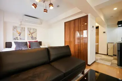 a living room with a couch and a bed at HOTEL AIS HATAGAYA in Tokyo