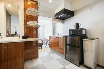 a kitchen with a refrigerator and a microwave at HOTEL AIS HATAGAYA in Tokyo