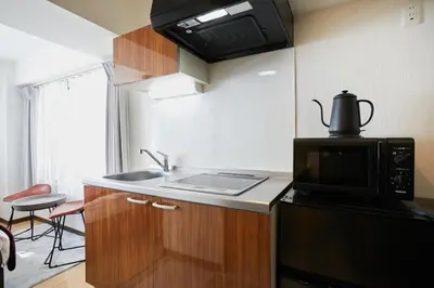 a small kitchen with a sink and a microwave at HOTEL AIS HATAGAYA in Tokyo