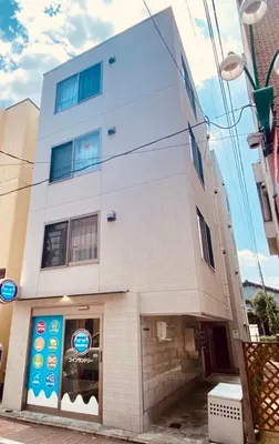 a white building with a sign on the side of it at HOTEL AIS HATAGAYA in Tokyo