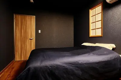 a bedroom with a large bed and a wooden door at 634 Condo Yotsuya - Vacation STAY 14799v in Tokyo
