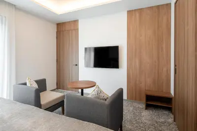a hotel room with a bed and two chairs and a table at Tokyu Stay Shinjuku Eastside in Tokyo
