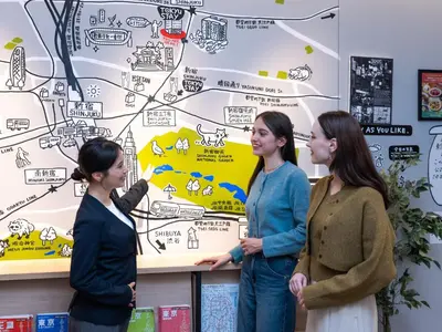 three women standing in front of a wall with a map at Tokyu Stay Shinjuku Eastside in Tokyo