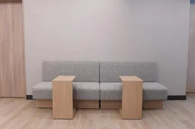 a gray couch in a room with two wooden tables at R&B Hotel Otsuka Eki Kitaguchi - Vacation STAY 14227v in Tokyo