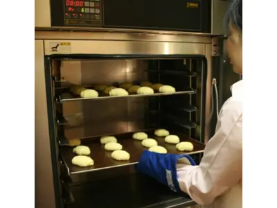 a person is putting food in an oven at R&B Hotel Otsuka Eki Kitaguchi - Vacation STAY 14221v in Tokyo