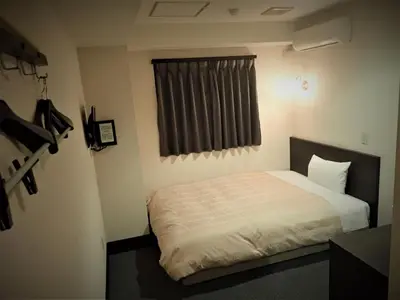 a small bedroom with a bed with a window at Hotel Suntargas Ueno - Vacation STAY 08484v in Tokyo