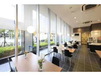 a restaurant with wooden tables and chairs and windows at R&B Hotel Tokyo Toyocho - Vacation STAY 14234v in Tokyo
