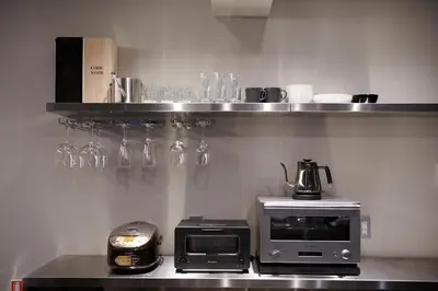 a kitchen with a microwave and glasses on a shelf at 634 Condo Shinjuku - Vacation STAY 14798v in Tokyo
