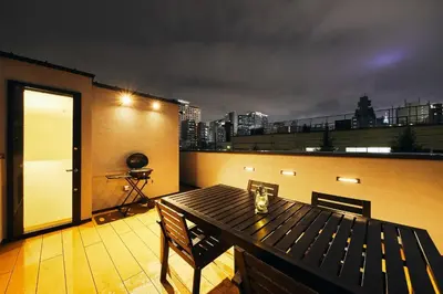 a wooden table on a balcony with a view of a city at 634 Condo Shinjuku - Vacation STAY 14798v in Tokyo
