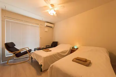 a room with two beds and a chair and a window at Terrace house omori in Tokyo