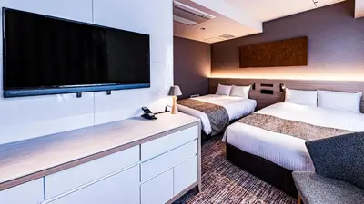 a hotel room with two beds and a flat screen tv at The Kanzashi Tokyo Asakusa in Tokyo