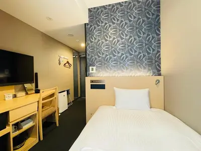 a room with a bed and a desk and a tv at The Kanzashi Tokyo Asakusa in Tokyo