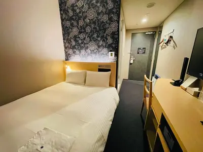 a hotel room with a large bed and a tv at The Kanzashi Tokyo Asakusa in Tokyo