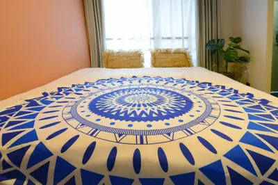 a blue and white comforter on a bed at Luana Shibuya in Tokyo