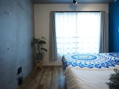 a bedroom with two beds and a large window at Luana Shibuya in Tokyo