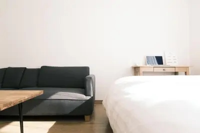 a living room with a couch next to a bed at Noah Ikebukuro - Vacation STAY 10604 in Tokyo