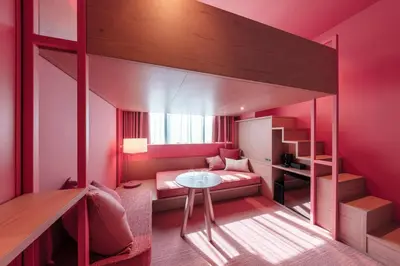 a pink room with a bunk bed and a table at toggle hotel suidobashi TOKYO in Tokyo