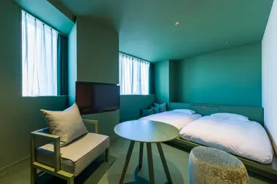 a bedroom with a bed and a table and a chair at toggle hotel suidobashi TOKYO in Tokyo