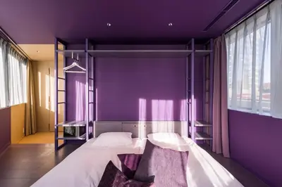 a bedroom with purple walls and a bunk bed at toggle hotel suidobashi TOKYO in Tokyo