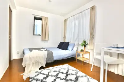 a small bedroom with a bed and a window at FL Residence Asakusa in Tokyo