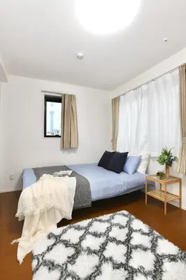 a bedroom with a blue bed and a rug at FL Residence Asakusa in Tokyo