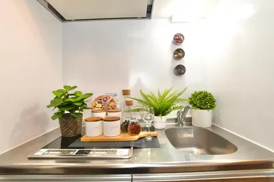 a kitchen counter with plants and a sink at FL Residence Asakusa in Tokyo