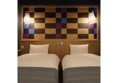 two beds in a room with a checkered wall at Sakura Sky Hotel - Vacation STAY 18445v in Tokyo