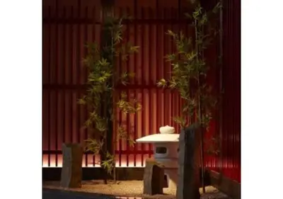 a table and two trees in front of a red wall at Sakura Sky Hotel - Vacation STAY 18432v in Tokyo