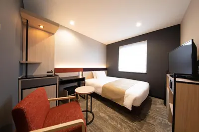a hotel room with a bed and a chair at Almont Hotel Nippori in Tokyo