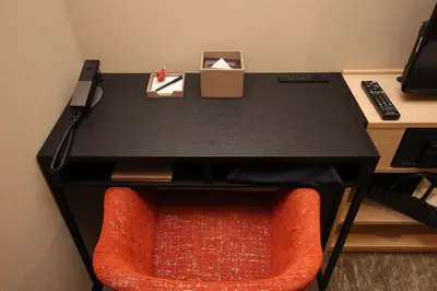 a black table with a red chair and a desk at Almont Hotel Nippori in Tokyo