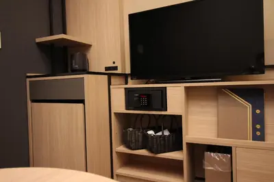 a flat screen tv on a wooden entertainment center at Almont Hotel Nippori in Tokyo