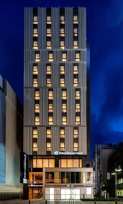 a tall building with lights on in a city at DEL style Ikebukuro Higashiguchi by Daiwa Roynet Hotel in Tokyo