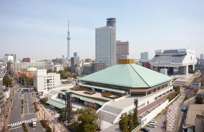 a large building with a green roof in a city at Pearl Hotel Ryogoku in Tokyo