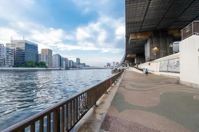 a walkway next to a river in a city at Pearl Hotel Ryogoku in Tokyo