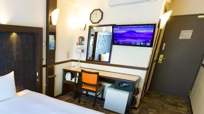 a hotel room with a desk and a mirror at Toyoko Inn Tokyo Shinagawa Konan-guchi Tennozu Isle in Tokyo