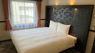 a bedroom with a white bed with a window at Toyoko Inn Tokyo Shinagawa Konan-guchi Tennozu Isle in Tokyo